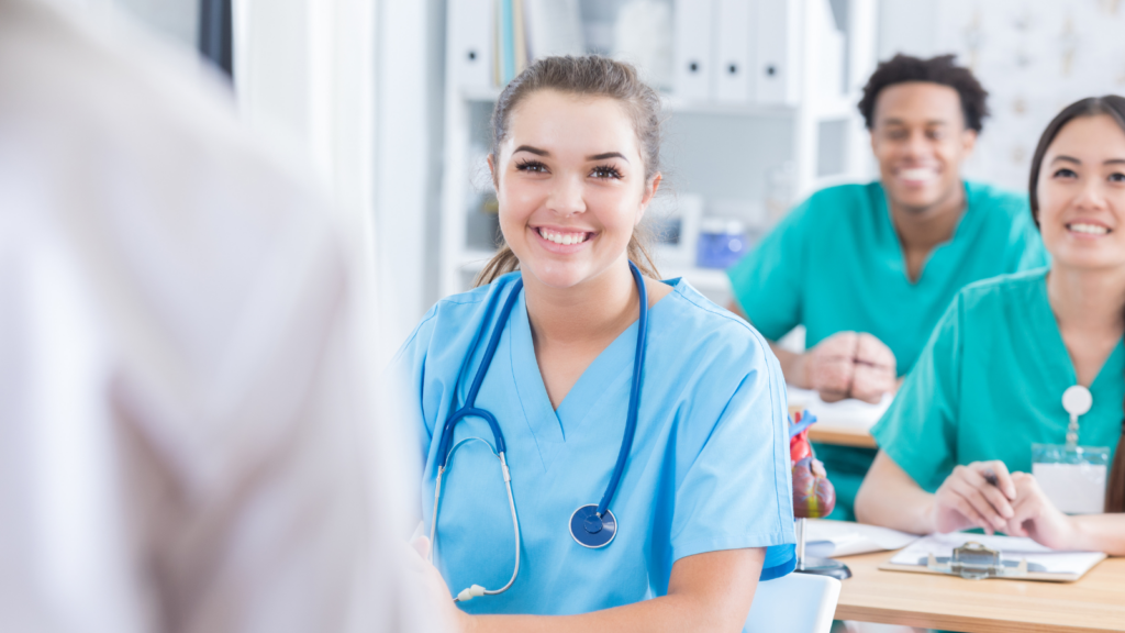 Nurse at a table in scrubs finding the Best travel nursing agencies