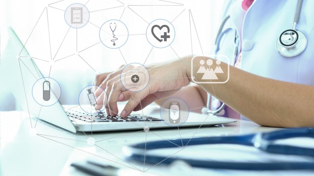 Nurse hands typing on Macbook laptop researching medical information and news.