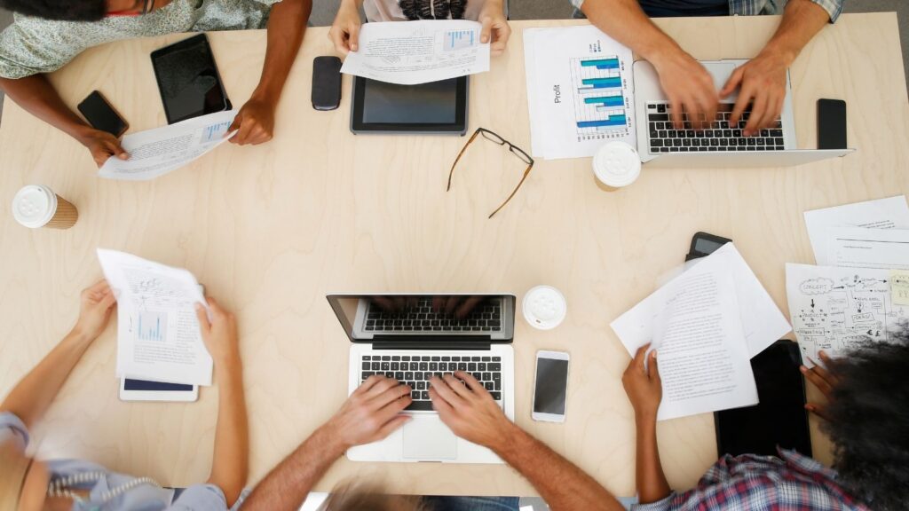 Top view of people working together on a table for a project.