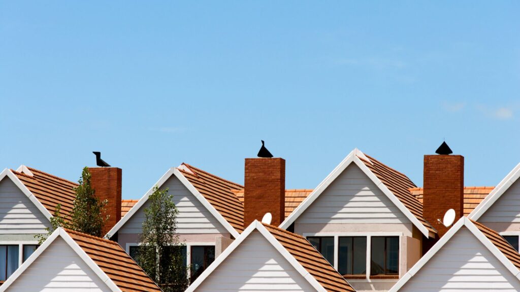 Group of white and brown houses in front of the blue sky. Housing stipend.