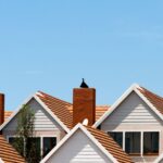 Group of white and brown houses in front of the blue sky. Housing stipend.