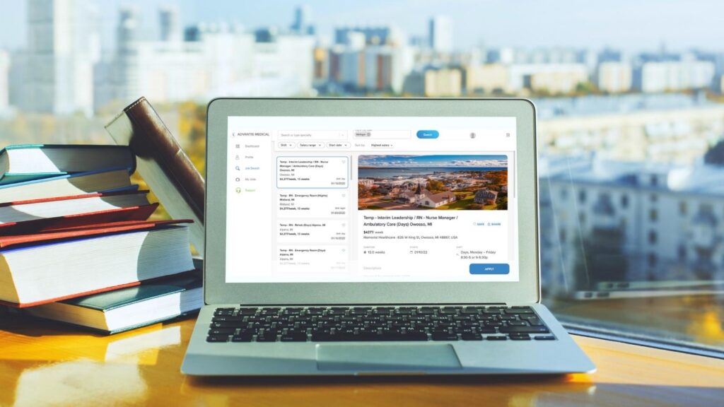 Laptop on desk with city view in background with job searching screen.