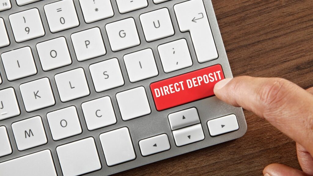 Close up of hands pressing direct deposit button on keyboard.