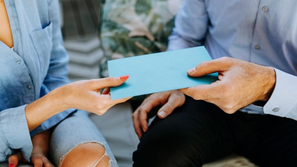Couple exchanging a card as a travel nurse Valentine’s Day gift.
