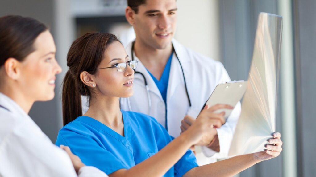Nurses and doctors looking at medical sheets in a hospital.