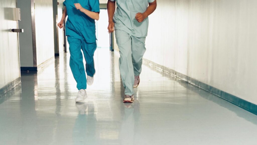 ER nurses running down a hall for an emergency.