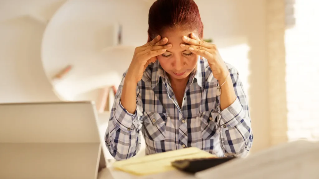 Woman sitting at a desk sad about congress capping travel nurse pay.