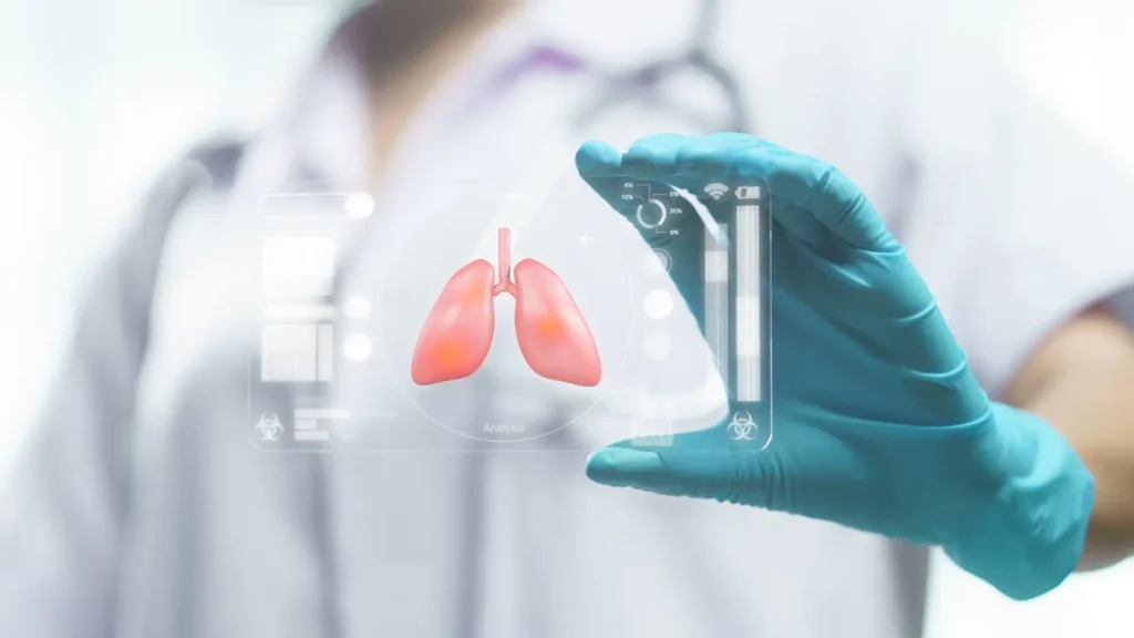 Respiratory Therapist nurse wearing white medical scrubs and light blue latex gloves holding a transparent acrylic frame with a miniature lung model.