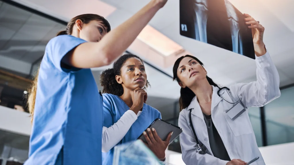 3 Travel Radiology Techs look at x-ray in examples of roles to earn highest travel rad tech salary